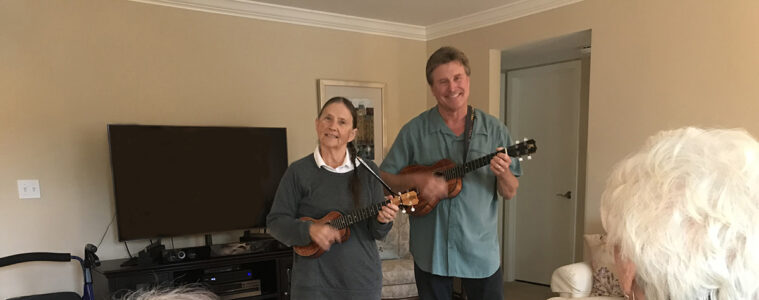 Nancy and Patrick Drigans playing ukulele for a group of seniors